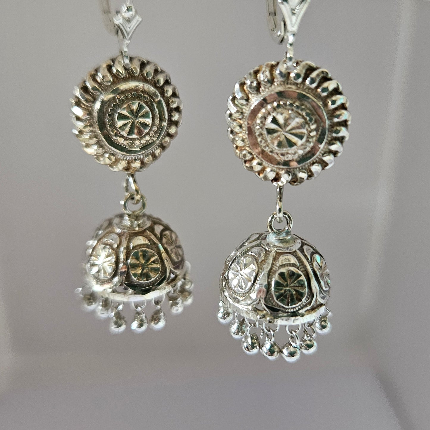 Decorative silver earrings on a white background