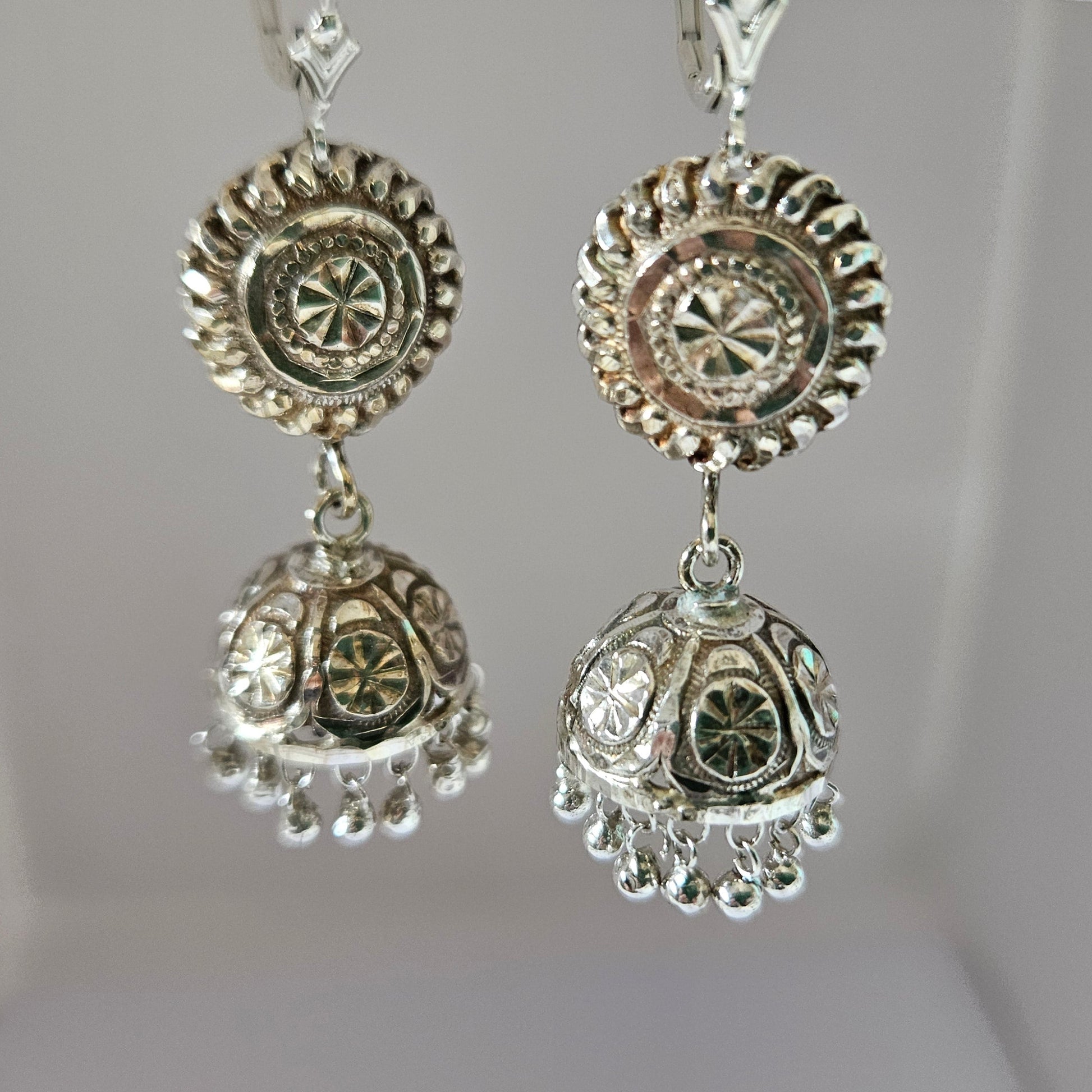 Decorative silver earrings on a white background